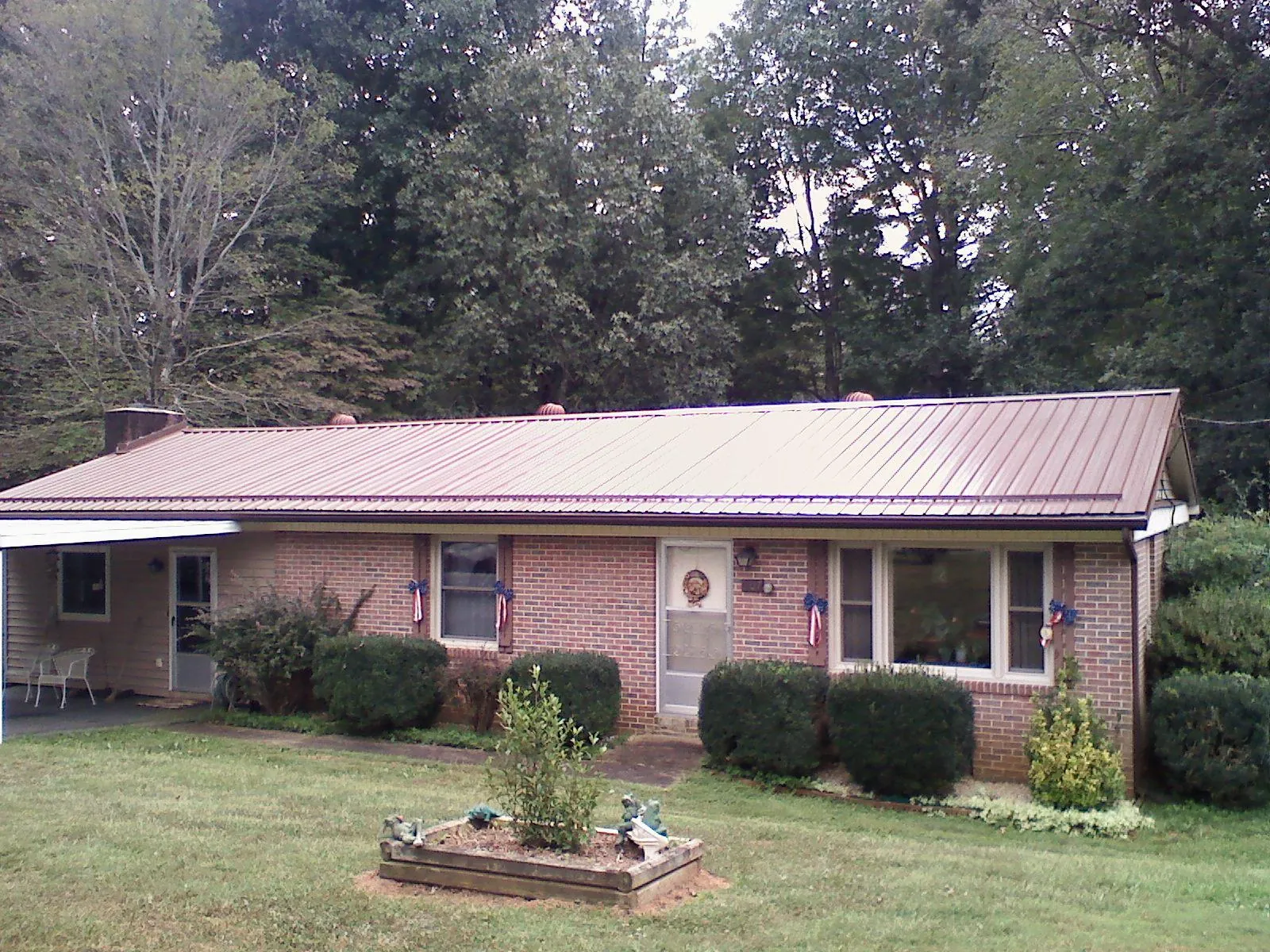 Bronze metal roof on a brick ranch home with a carport in Panama